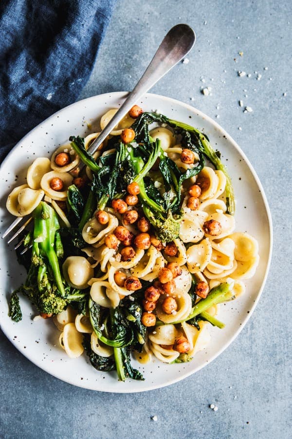 Broccoli Rabe Pasta on a white plate with a fork and a black napkin.