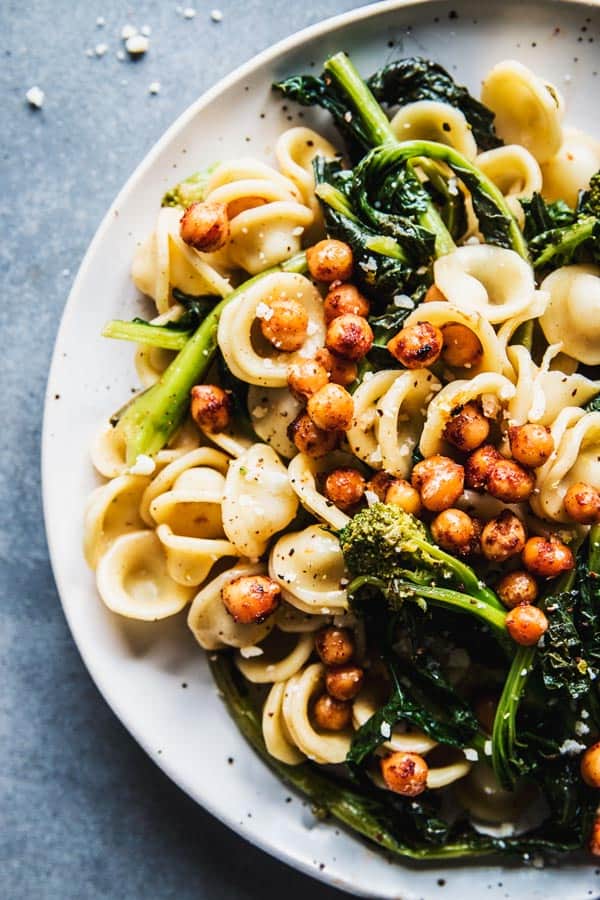 Close up of broccoli rabe pasta on a white plate.