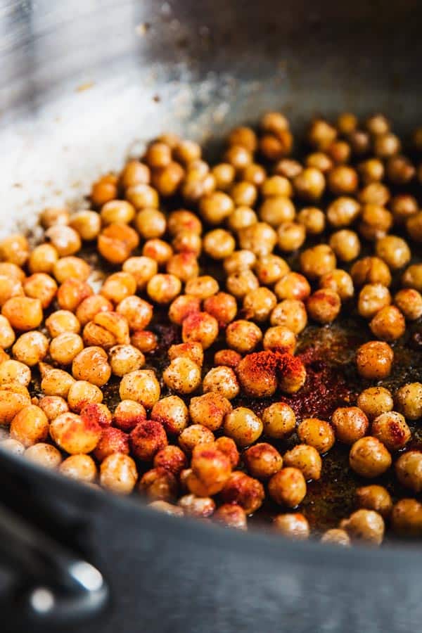 Chickpeas in a skillet with olive oil and smoked paprika.