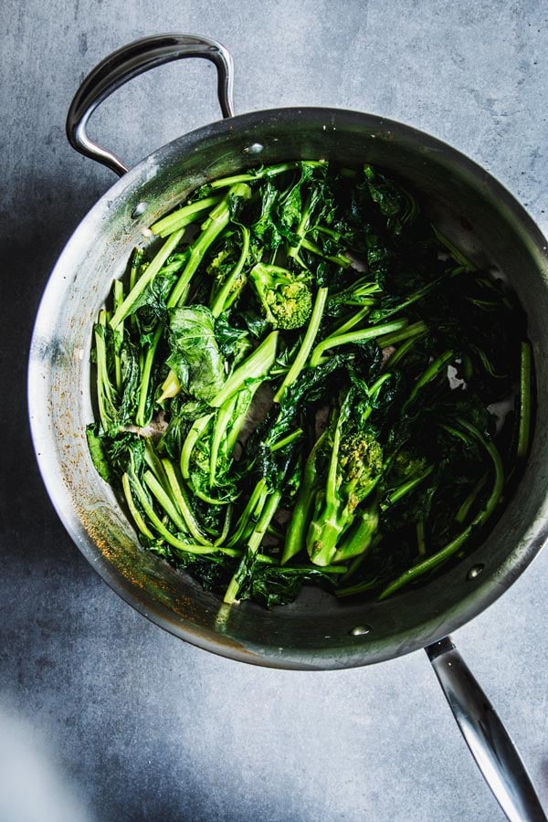 Wilted broccoli rabe in a skillet.
