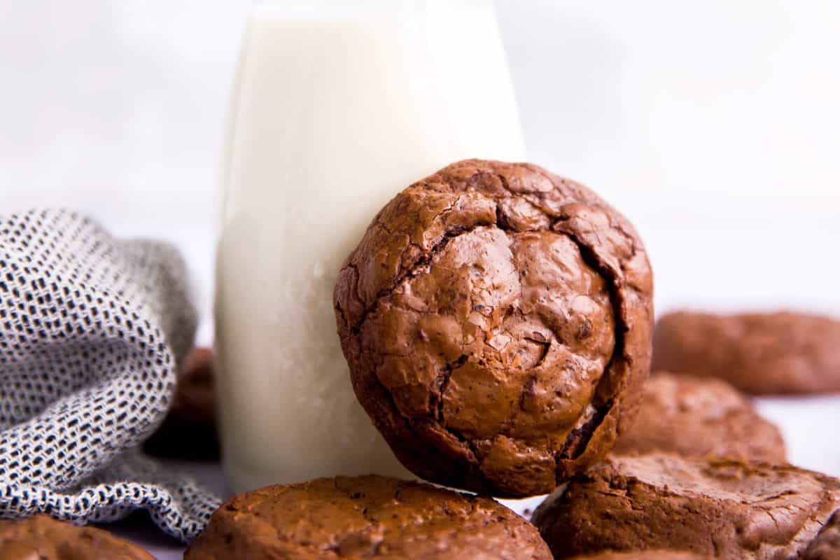 brownie cookie leaning against a bottle of milk