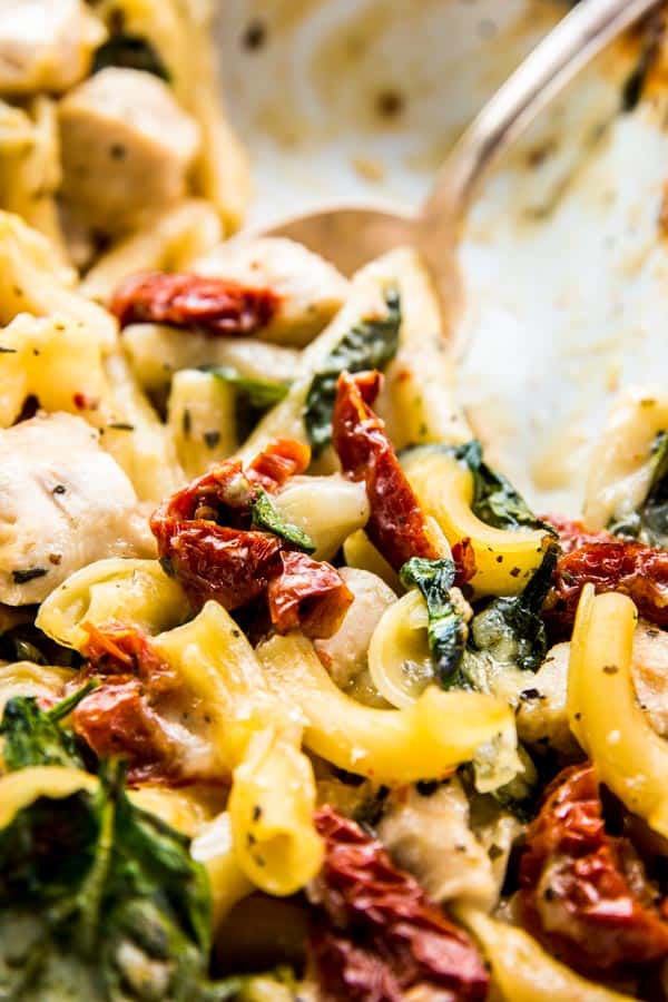 Close up photo of Chicken Florentine Pasta Casserole with sun-dried tomatoes, chicken and spinach.