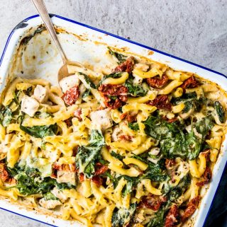 Chicken Florentine Pasta Casserole in a enamel casserole dish with a silver spoon.