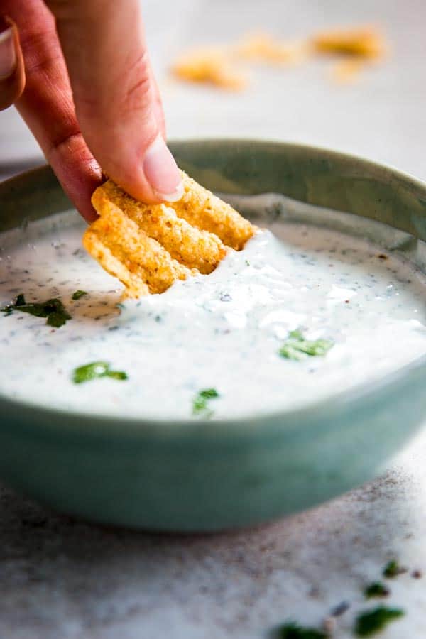 Dipping a chip in ranch dip.