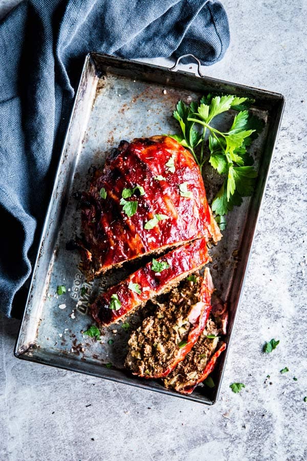This Bacon Wrapped Meatloaf is pure comfort food! This classic dinner recipe gets upgraded with yummy flavors and a bacon wrapping - the best way to serve this traditional family meal! | #recipe #easyrecipes #groundbeef #groundbeefrecipes #dinner #easydinner #comfortfood bacon wrapped meatloaf in a casserole dish