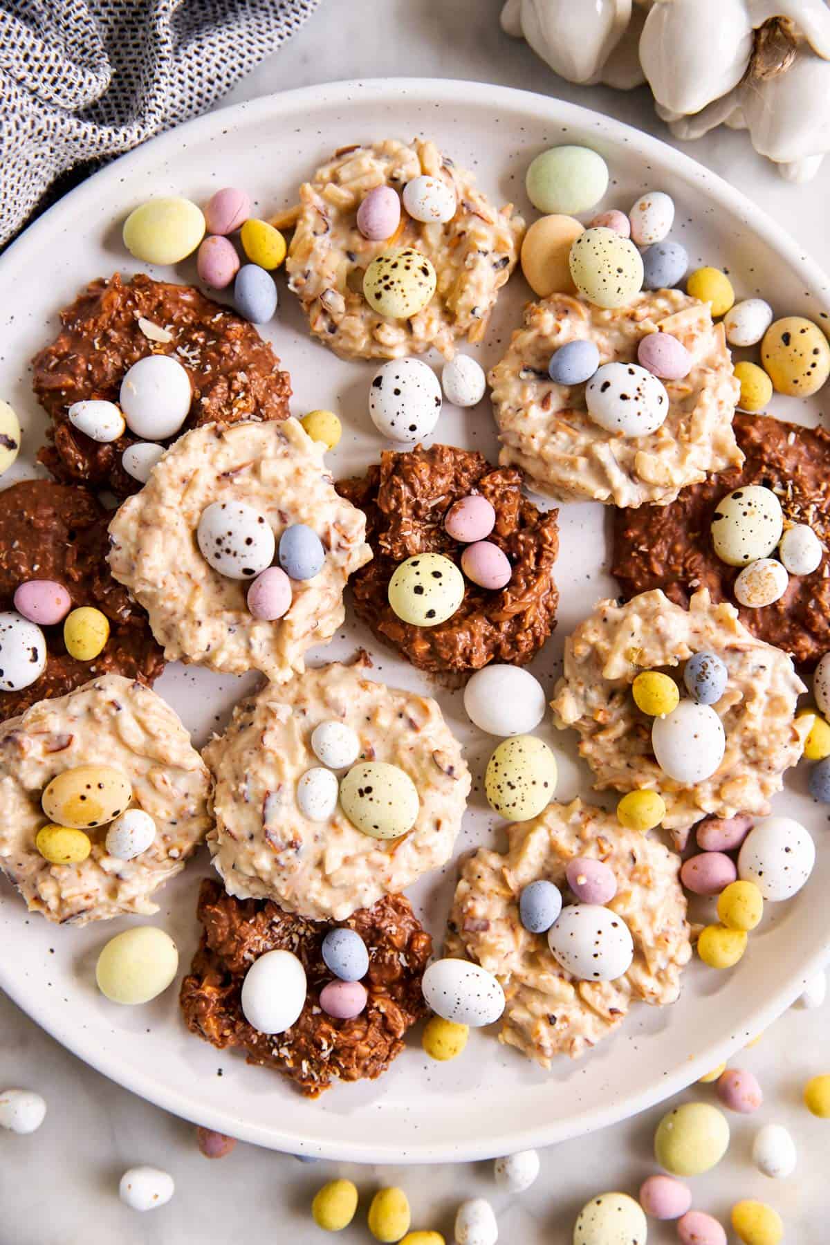 overhead view of white plate with bird's nest cookies and mini eggs