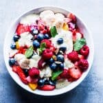 Creamy fruit salad in a white bowl.