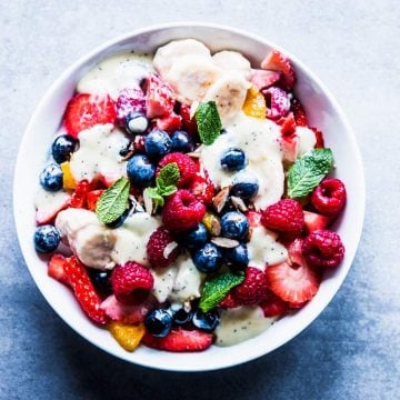 Creamy fruit salad in a white bowl.