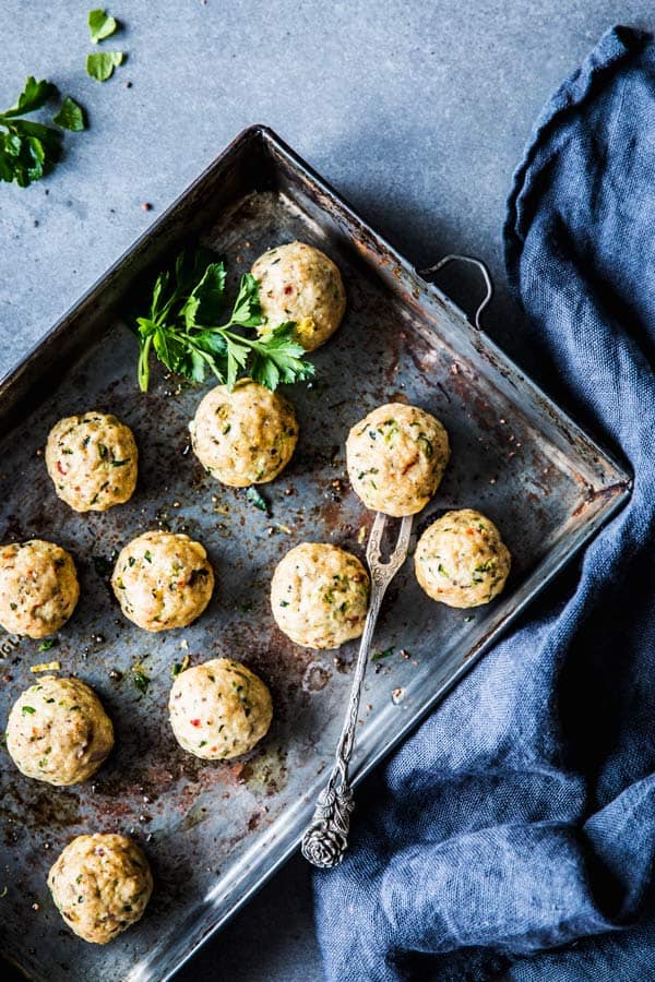 Greek turkey meatballs on a baking sheet with a black napkin.