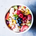 Greek Yogurt Fruit Salad in a white bowl on a counter top.