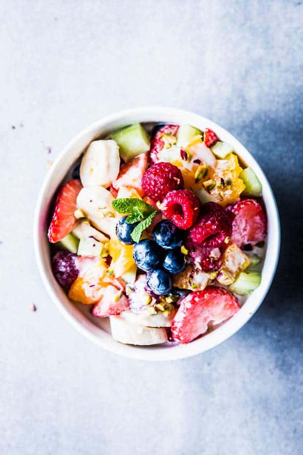 Greek Yogurt Fruit Salad in a white bowl on a counter top.