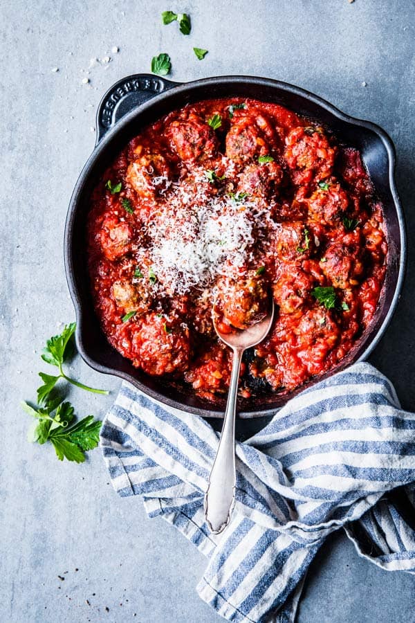 Easy Italian Meatballs in tomato sauce in a black cast iron skillet.