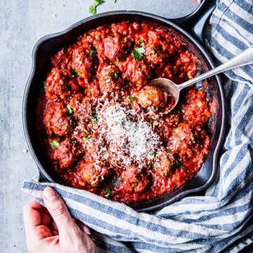 Serving easy Italian meatballs in tomato sauce from a black cast iron skillet.