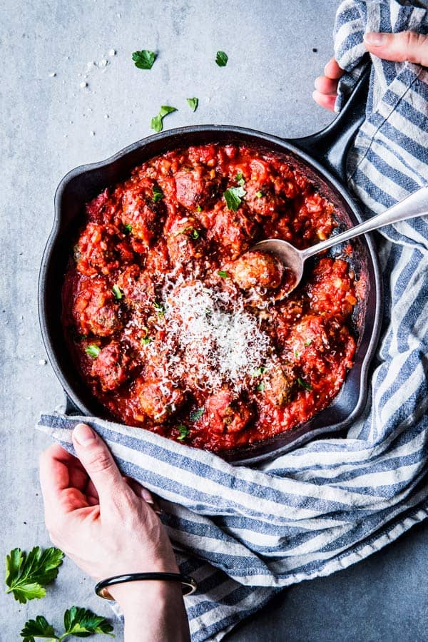 Serving easy Italian meatballs in tomato sauce from a black cast iron skillet.
