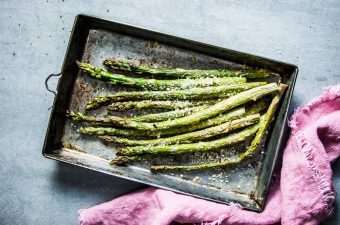 Garlic Parmesan Roasted Asparagus on a sheet pan, next to a pink napkin.