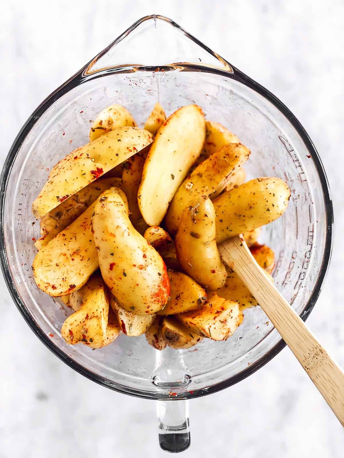 glass bowl filled with seasoned fingerling potatoes