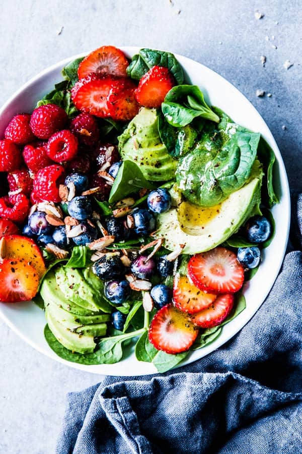 Spinach Avocado Salad in a white bowl with a black napkin.