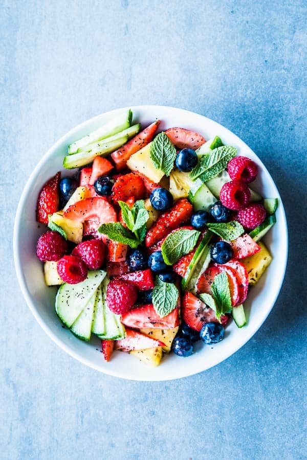 Summer fruit salad in a white bowl.