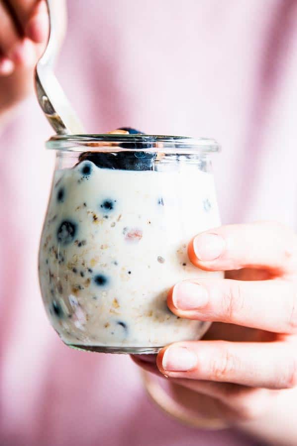 Woman eating blueberry overnight oats