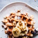 Banana nut waffles on a white plate.