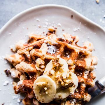 Banana nut waffles on a white plate.