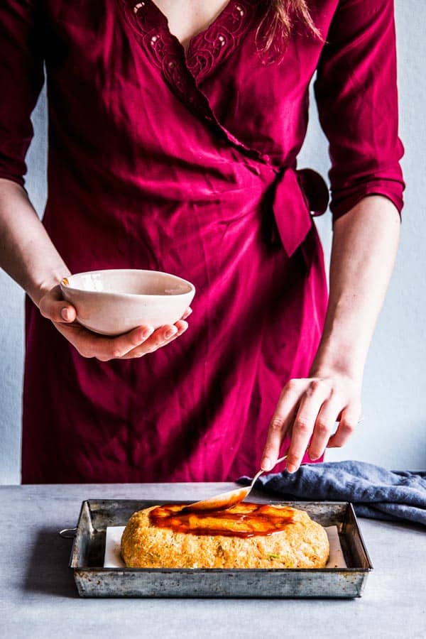 Woman brushing turkey meatloaf with bbq sauce