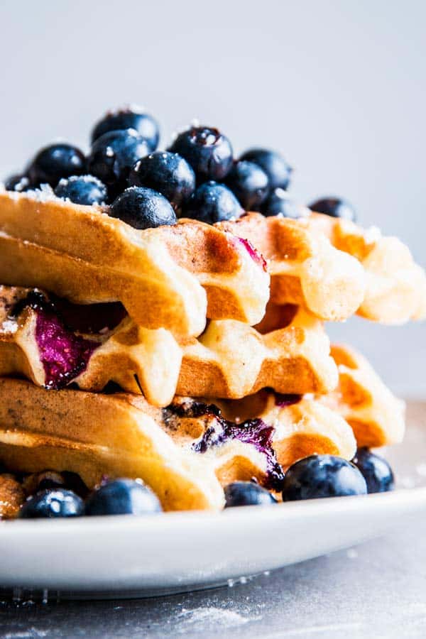 Stack of blueberry waffles on a plate.