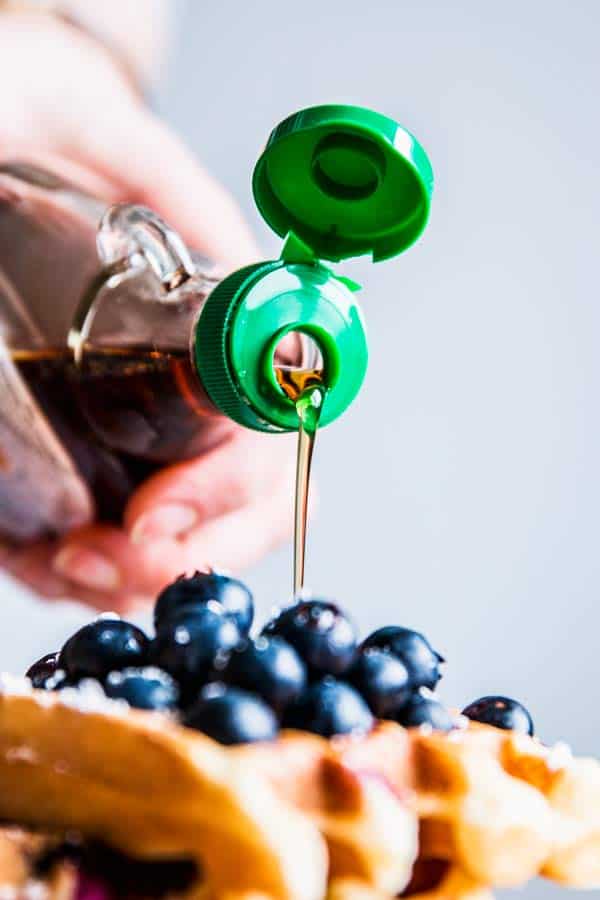 Pouring syrup over Blueberry Waffles.