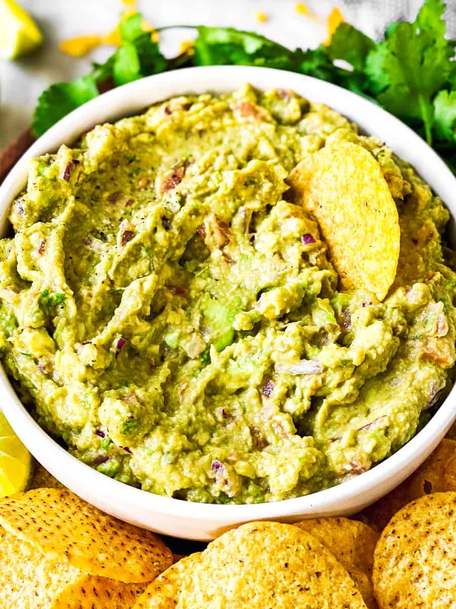 frontal view of guacamole in bow with a chip