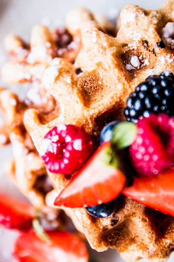 Close up photo of Fluffy Whole Wheat Waffles topped with berries.