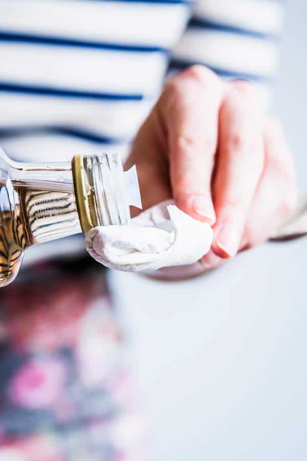 Woman in a striped shirt drizzling vinegar on a paper towel.