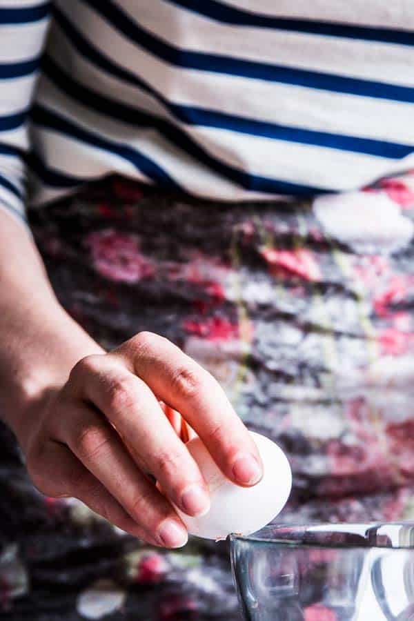 Woman cracking an egg.