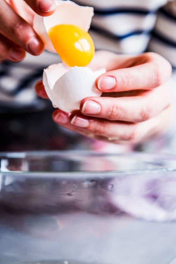Woman separating the egg yolk from the egg white.