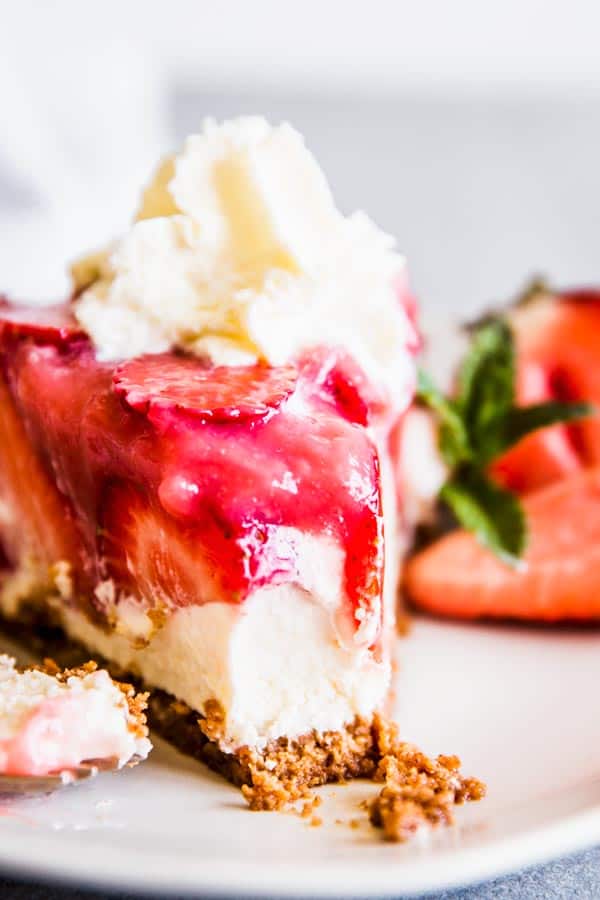 No bake strawberry cheesecake pie on a plate with whipped cream