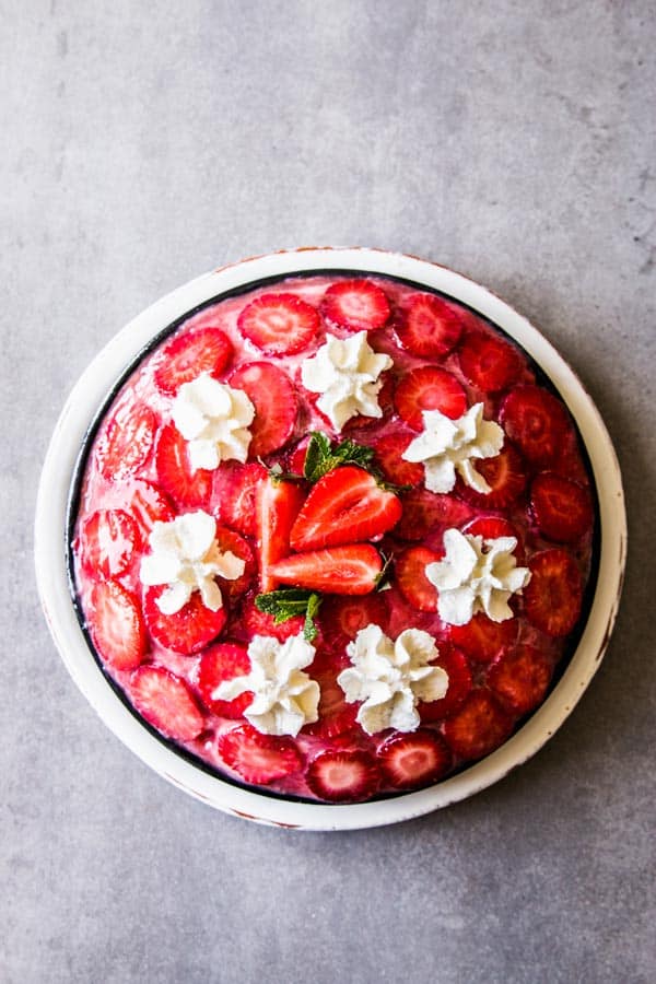 No Bake Strawberry Pie with Cream Cheese Layer, garnished with whipped cream.