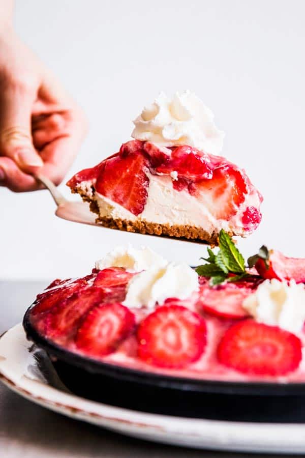 Scooping a slice of no bake strawberry pie.