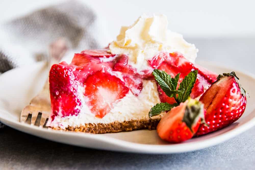 No Bake Strawberry Pie on a plate with fresh strawberries.