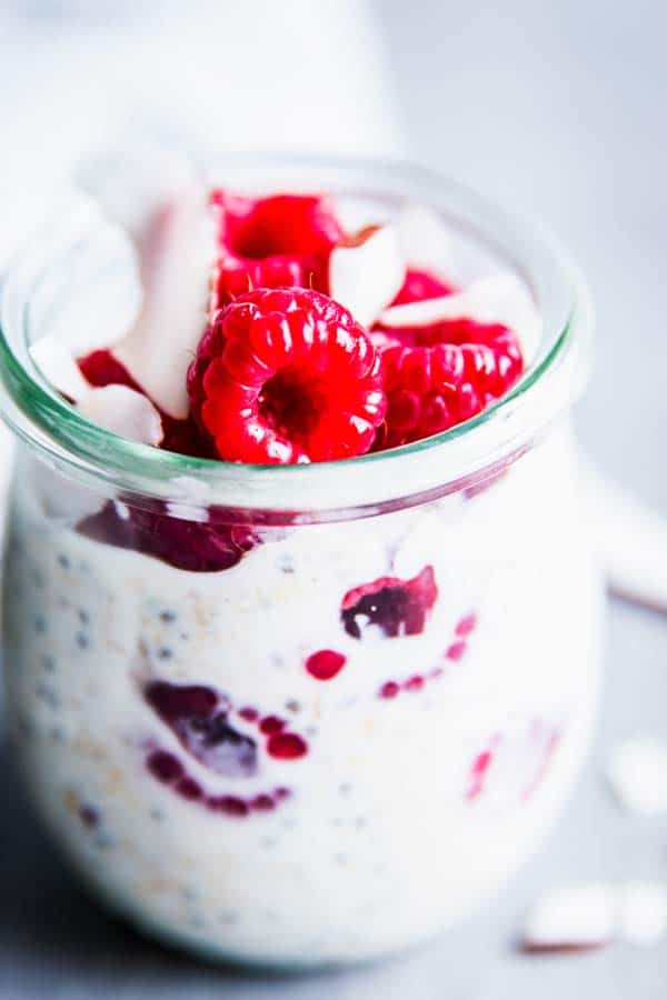 Raspberry Coconut Overnight Oats in a glass jar on the table.