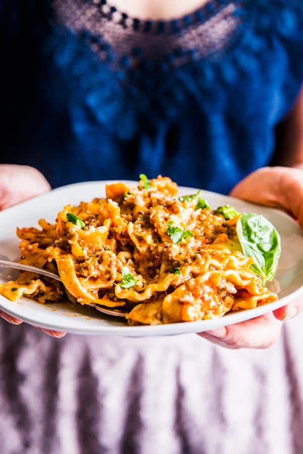 Woman holding a plate filled with skillet lasagna