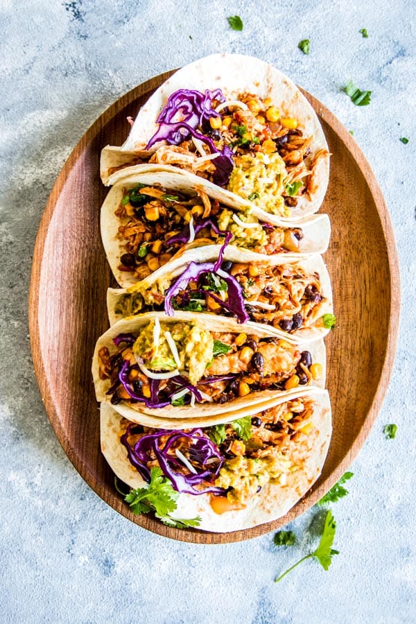 Southwestern crockpot chicken tacos on a wooden platter