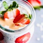 Strawberry peanut butter overnight oats in a glass jar with sliced strawberries