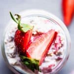 Vanilla Strawberry Overnight Oats in a jar with sliced strawberries.