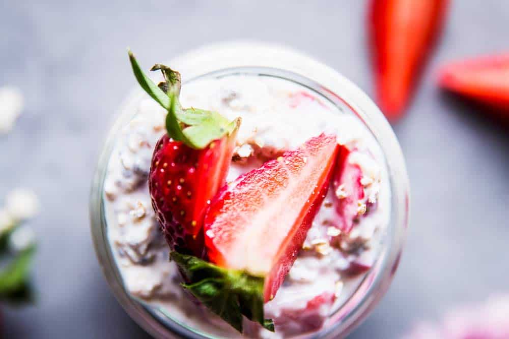 Vanilla Strawberry Overnight Oats in a jar with sliced strawberries.
