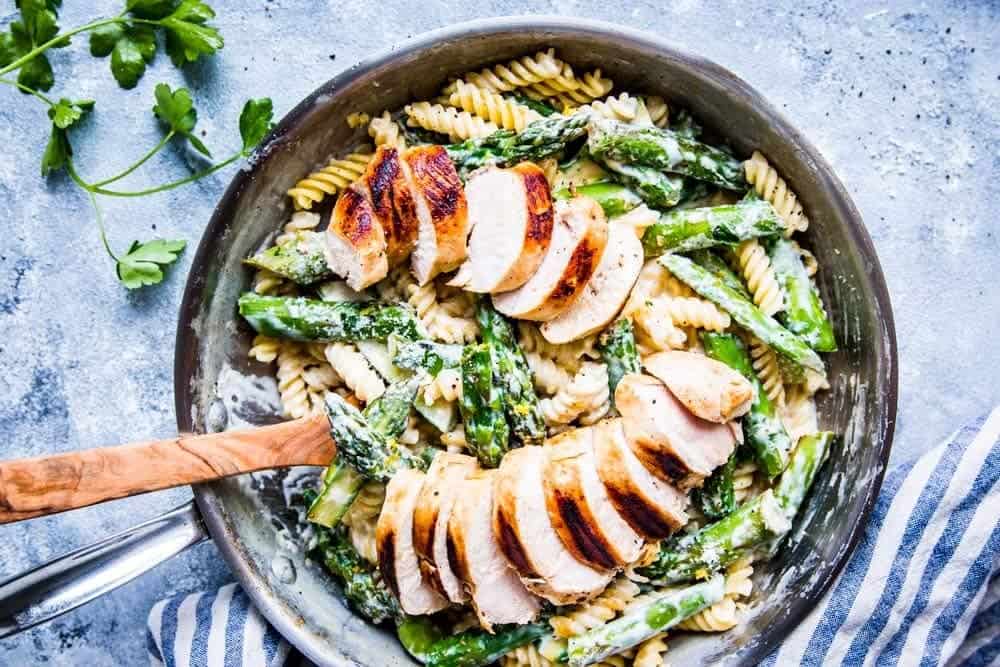 chicken asparagus pasta in creamy sauce in a skillet