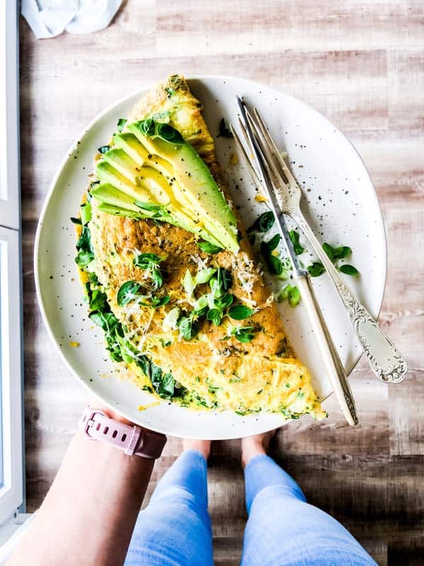 woman holding an omelet on a white plate