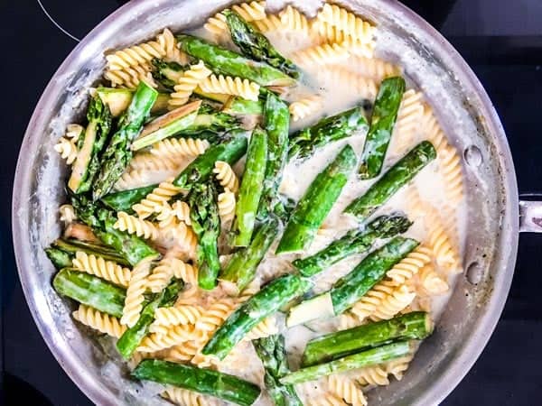 pasta and asparagus in a skillet in creamy sauce