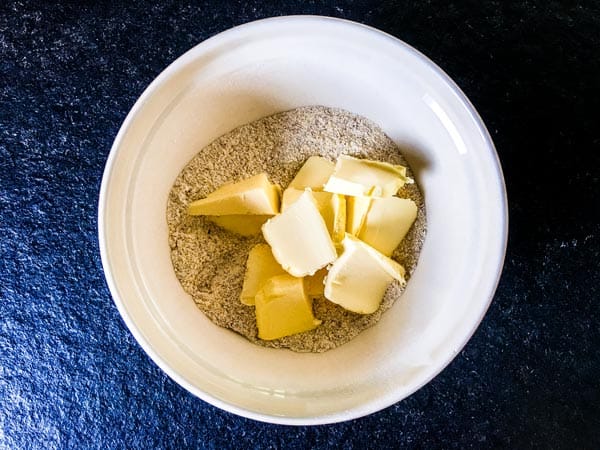 butter and flour in a bowl to make biscuits for fresh cherry cobbler