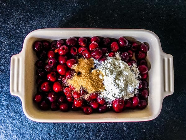 cherries, flour and sugar in a baking dish for cherry cobbler