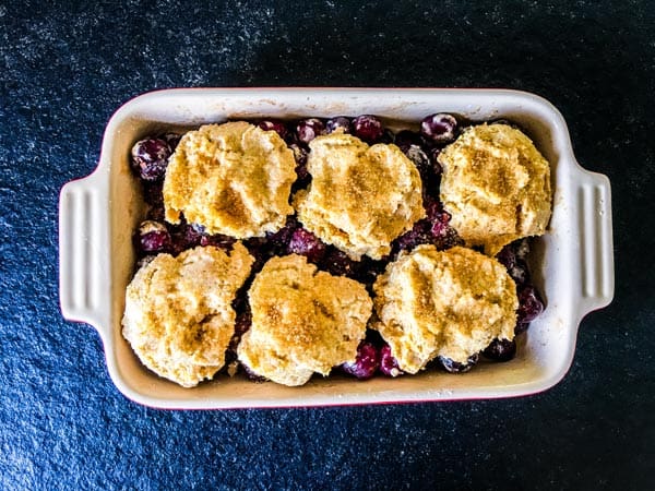 fresh cherry cobbler sprinkled with sugar ready for the oven