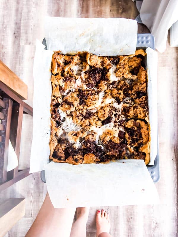 holding a pan of oatmeal cookie s'mores bars